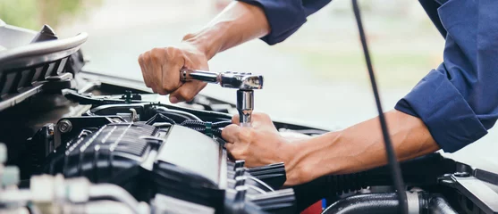 Foto op Canvas Automobile mechanic repairman hands repairing a car engine automotive workshop with a wrench, car service and maintenance,Repair service. © A Stockphoto