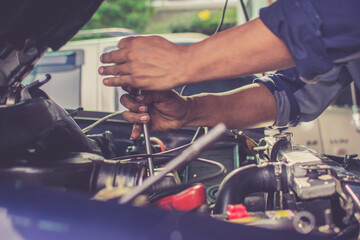 The mechanic is repairing the engine for customers who come to use the service.