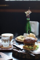 Beef burger served with Tuna toast, potato fries, blueberry waffle and hot coffee