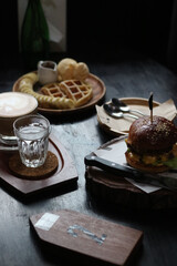 Beef burger served with Tuna toast, potato fries, blueberry waffle and hot coffee
