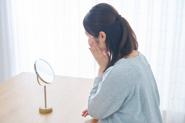 美容　鏡を見る女性　リビング