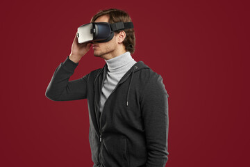 Calm man exploring virtual world in VR glasses