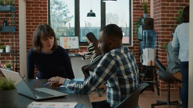 Young woman greeting HR manager at job application meeting, analyzing cv resume and talk about business employment. Female candidate attending interview with male recruiter in office.