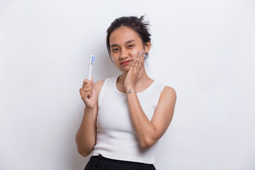 Young beautiful asian woman brushing her teeth isolated on white background
