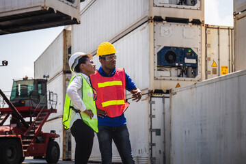 Female foreman and worker man in hardhat control loading containers box from cargo