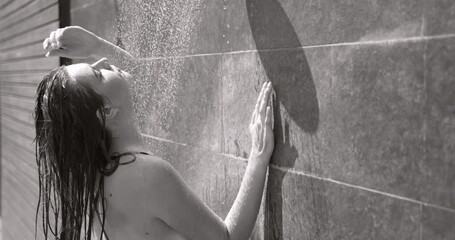 A girl is taking shower after sunbathing outdoors