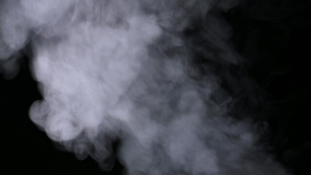 steam of boiling water on black background