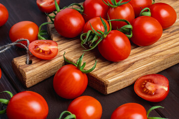 Red tomato in glass bowl on cutting board on wooden table. Organic healthy food. Cooking Ingredients