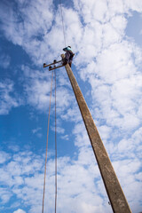 Man working on the top electric pole