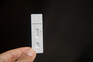 Rapid antigen test (RAT) with COVID-19 Ag inscription.2 stripes showing a POSITIVE result. 