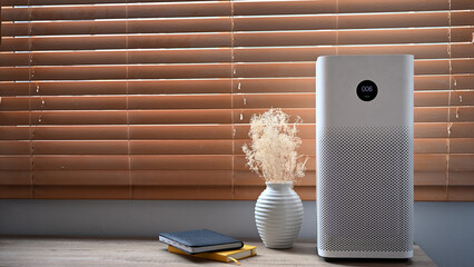 Air purifier in front of windows in living room for fresh air and healthy life. Air Pollution...