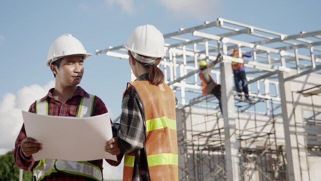 Two architect and client discussing help create plan with blueprint home building at construction site