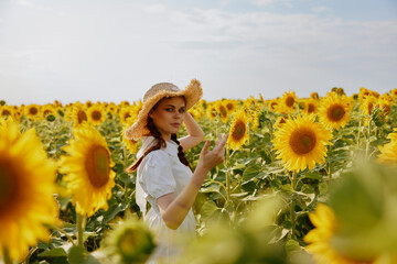 Fototapeta na wymiar woman with two pigtails In a field with blooming sunflowers landscape