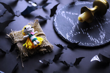 Halloween holiday concept. Old stone table in a shape of bats. Halloween paper decorations on dark background. Moon toy.