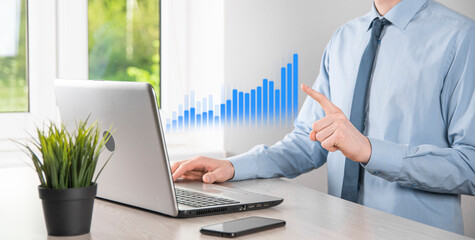 Business man holding tablet and showing holographic graphs and stock market statistics gain profits. Concept of growth planning and business strategy. Display of good economy form digital screen.