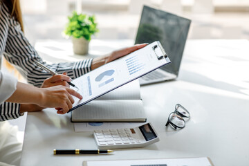 Financial Business woman analyze the graph of the company's performance to create profits and growth, Market research reports and income statistics, Financial and Accounting concept.