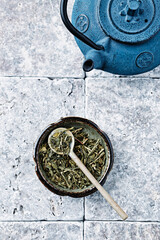 Dried Green Tea Leaves on rustic stone Background. Top view. Copy space.