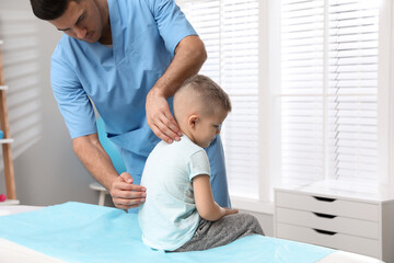 Orthopedist examining child's back in clinic. Scoliosis treatment