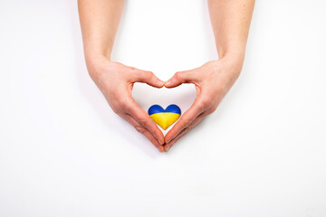 Heart flag of Ukraine in human hands. No war, peace for Ukraine concept.