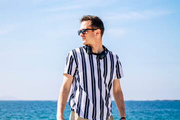 young man walking on the beach with headphones