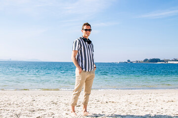 young man walking on the beach with headphones