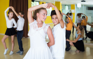 Portrait of smiling young children enjoying of partner dance in class