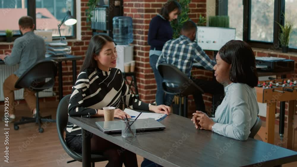 Poster asian employee interviewing african american candidate to explain job offer and work application. hu