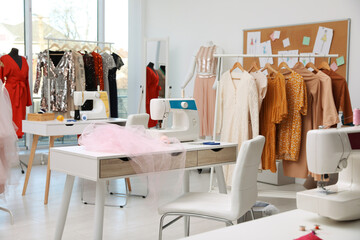 Obraz na płótnie Canvas Dressmaking workshop interior with stylish female clothes and equipment