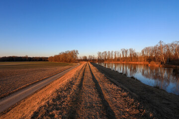 Abendlicher Spaziergang bei Sonnenuntergang am Uferdamm des  Lech Kanal bei Meitingen, Ostendorf im Landkreis Augsburg, Schwaben, Bayern.	