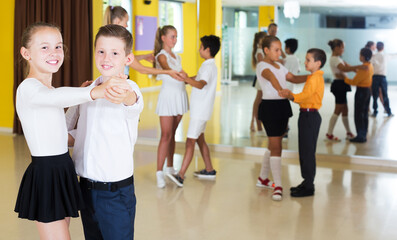 Fototapeta na wymiar Boys and girls in dance class studying new movements, smiling and having fun
