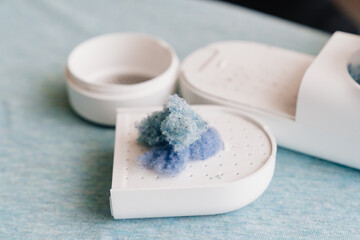 a disassembled machine for removing pellet and spools from clothes and fabric on blue fabric. A modern electronic device for updating old things.