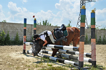 Falling rider with a horse while overcoming a barrier
