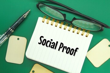 glasses, pens and notebooks with the word social proof