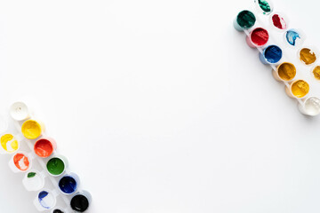 Flat composition a set of multi-colored paints in jars. Space for the text.