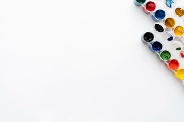 Flat composition a set of multi-colored paints in jars. Space for the text.