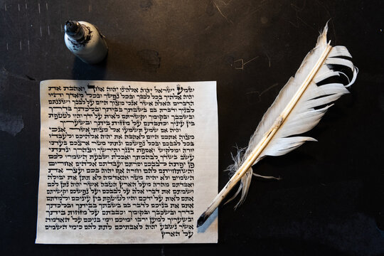 Mezuzah parchment made from animal skin with the full text of the Shema Yisrael prayer in Hebrew and a feather quill used to write the Hebrew text taken from the Bible.
