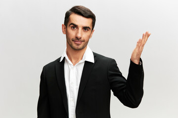 a man in a business suit holds his hand in front of him marketing manager success at work light isolated background look Copy space at the camera