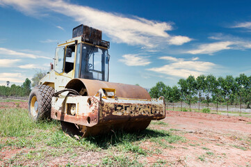 Obraz premium Compactor with sunlight and shadows on the surface of a large old compactor wheel of a road roller.