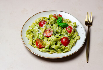 Linguini pasta with pesto sauce, tomatoes and cheese. Healthy eating. Vegetarian food. Italian cuisine.