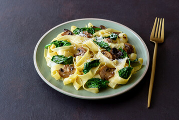 Linguini pasta with mushrooms, spinach and cheese. Healthy eating. Vegetarian food. Italian cuisine.