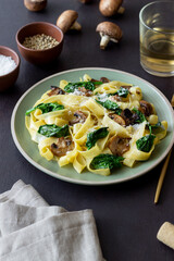 Linguini pasta with mushrooms, spinach and cheese. Healthy eating. Vegetarian food. Italian cuisine.
