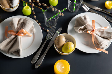 easter, holidays, tradition and object concept - close up of dinner party table serving over black background