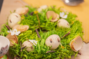 Bright green wreath decorated with Easter quail eggs. Festive decoration for the light holiday of Easter. Interior decoration. Decor elements. Preparing for spring holiday. Happy easter. Close up.