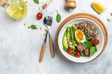 Keto diet plate quinoa, avocado, egg, tomatoes, spinach and sunflower seeds on light background. Healthy food, ketogenic diet, diet lunch concept, place for text, top view