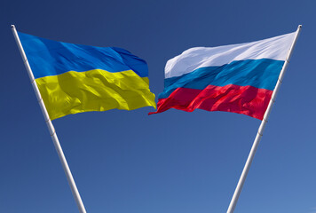Flags of Russia and Ukraine against a blue sky. Escalation of the conflict. The concept of confrontation.