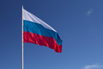 Russian flag on a background blue sky. Lens flare effect.