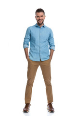 happy casual man with hands in pockets smiling