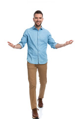 smiling man in denim shirt being happy, opening arms and welcoming