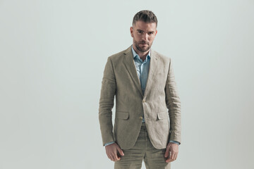 portrait of sexy unshaved guy in suit with open collar shirt posing