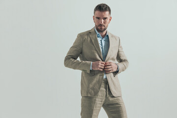 confident businessman with open collar shirt adjusting and closing suit